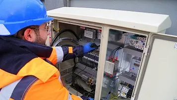 Electricista trabajando en caja eléctrica esterior