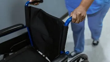 Enfermera llevando una silla de ruedas